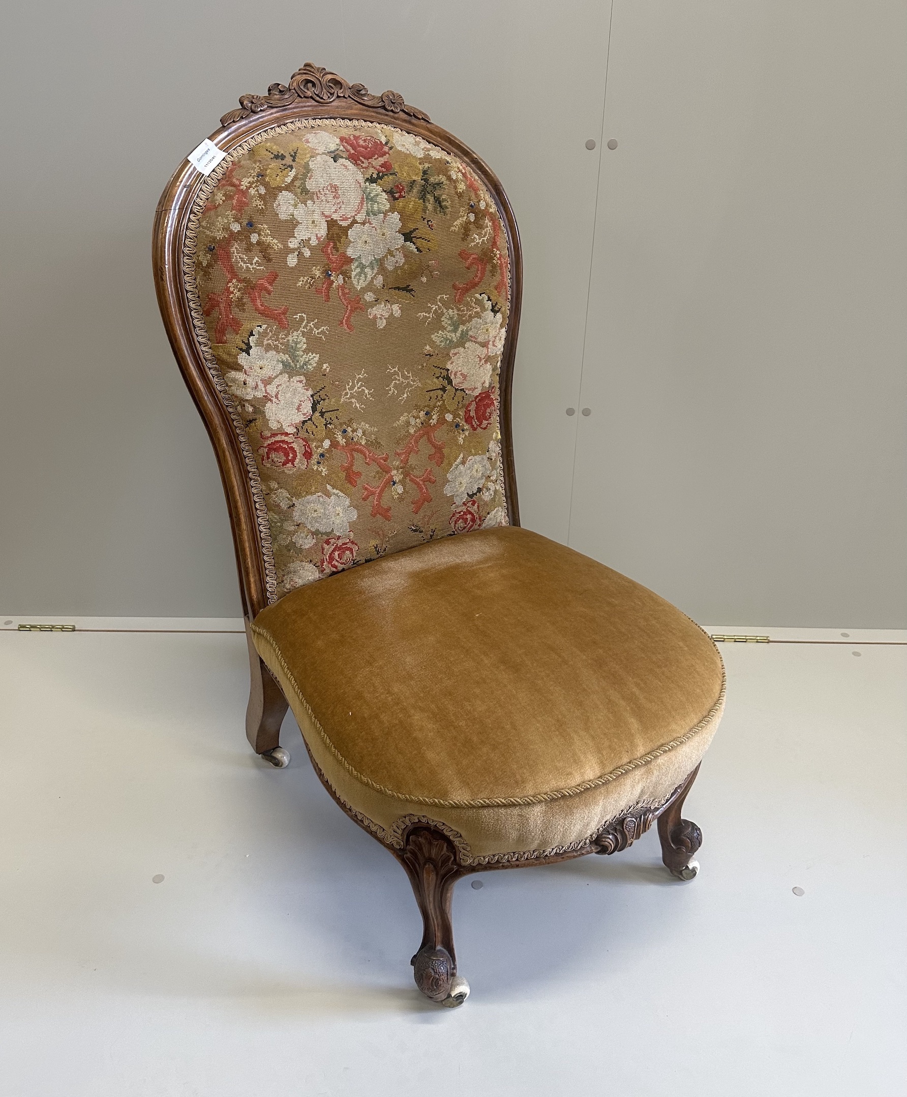 A Victorian walnut spoon back nursing chair, retaining original floral tapestry to back, width 50cm, height 100cm